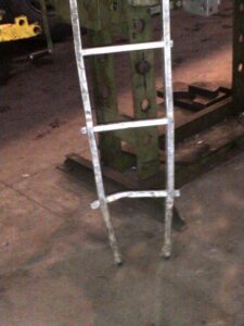 Obrázek ukazuje poškozený žebřík na pracovišti.