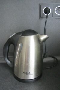 Používání vlastních el. spotřebičů na pracovišti Obrázek ukazuje konvici na pracovišti.