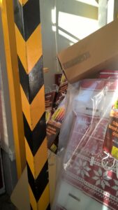 Požárně bezpečnostní zařízení Obrázek ukazuje schované tlačítko EPS pod zbožím.